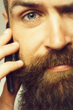 Sakallı adam cep telefonu ile