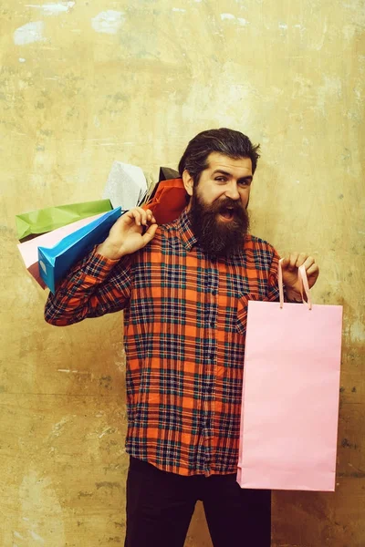 Happy bebaarde man met kleurrijke papieren draagtassen — Stockfoto