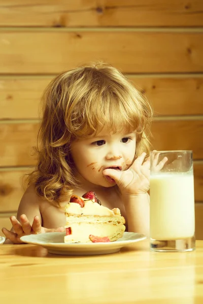 Kleine jongen met aardbeientaart en yoghurt — Stockfoto