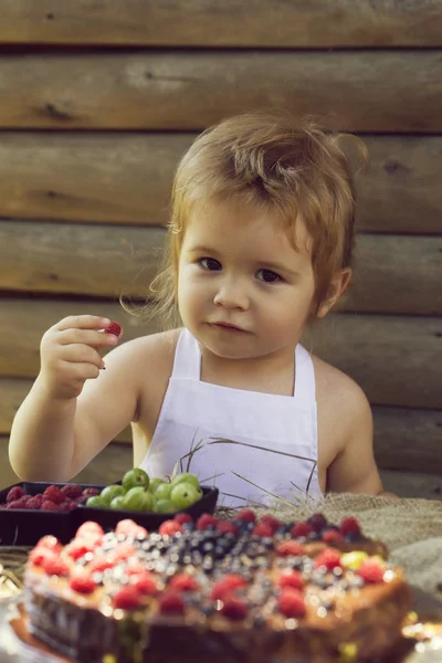 Little boy eats red raspberry — Stock Photo, Image