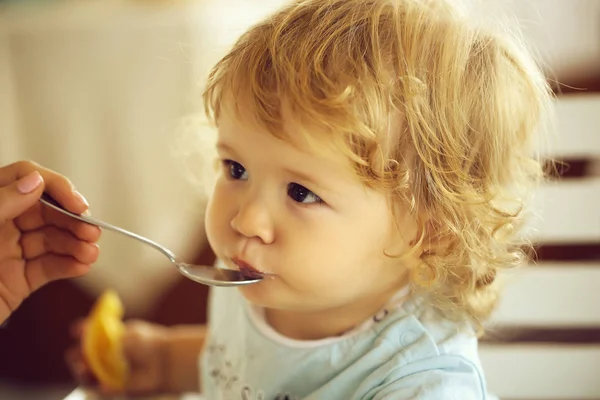 Baby boy fed with spoon Stock Picture