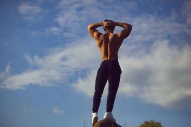 Gökyüzü arka plan üzerinde seksi kaslı adam