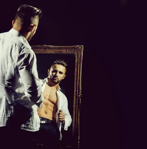 Gespierde macho man met sexy atleet lichaam in de buurt van vintage spiegel — Stockfoto