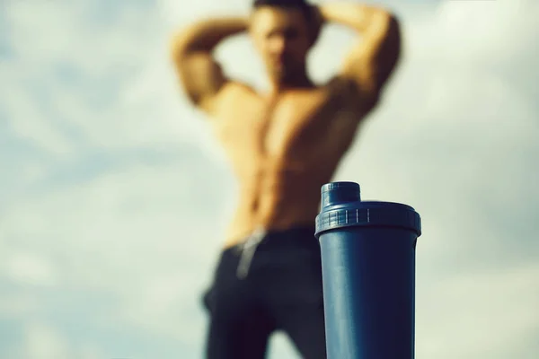 Homem muscular relaxante perto de garrafa de água — Fotografia de Stock