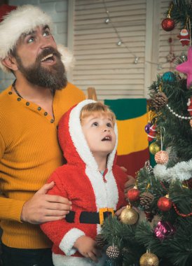 sakallı adam baba çocuğuna Noel süslemeleri yılbaşı ağacı