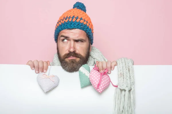 Guy with sad face in winter hat and scarf.