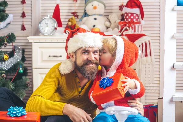 Santa claus kid en bebaarde man bij kerstboom. — Stockfoto