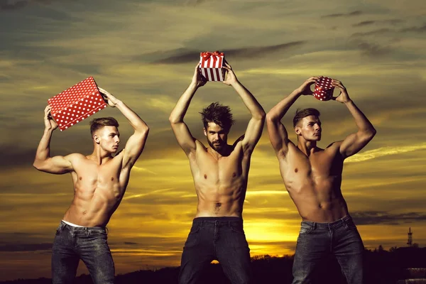 Hombres musculosos en la puesta de sol con cajas — Foto de Stock