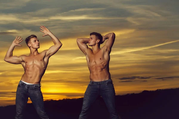 Hombres musculosos en la puesta de sol con cajas — Foto de Stock