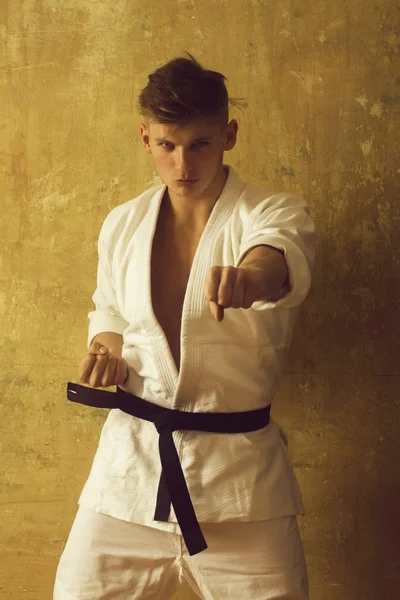 Strong fit athlete in white kimono with black belt — Stock Photo, Image