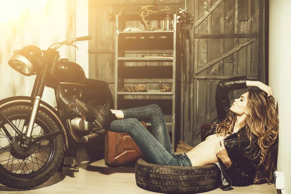 性感的女人躺在地板上的脏橡胶轮胎 — 图库照片