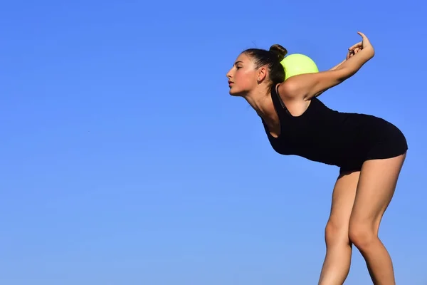 Kvinna gymnast i svart sportkläder med grön boll. — Stockfoto