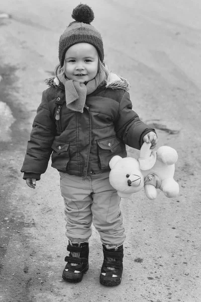 Piccolo ragazzo felice bambino tiene orsacchiotto giocattolo inverno all'aperto — Foto Stock