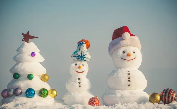 Snowmen with smiley faces in hats on winter day — Stock Photo, Image