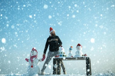 Adam ve mavi gökyüzü elele kardan adam