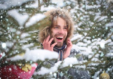 Köknar ağaçları karlı niteliğine gülümseyen adam