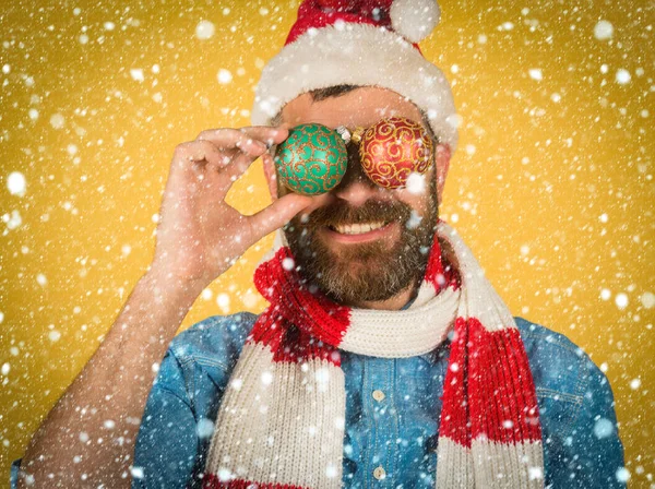 Jul man täcka ögon med xmas bollar på gul bakgrund — Stockfoto