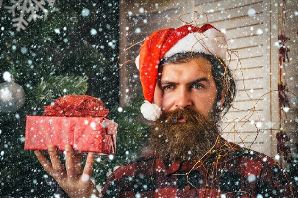 Santa claus man med nuvarande box på julgran — Stockfoto