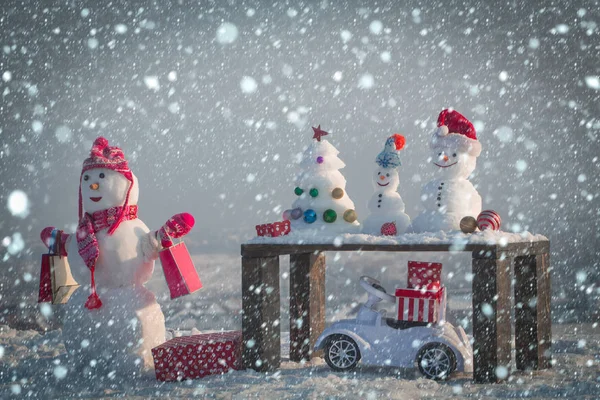 Gri gökyüzü arka plan üzerinde alışveriş torbaları ile kardan adam