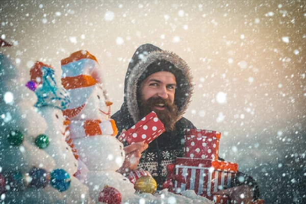 Homem feliz com caixas de presente na paisagem nevada — Fotografia de Stock