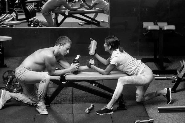 Arm wrestling muscular man and girl at gym — Stock Photo, Image