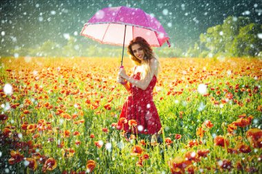 Kırmızı haşhaş alanın üzerinde pembe şemsiye ile mutlu kız