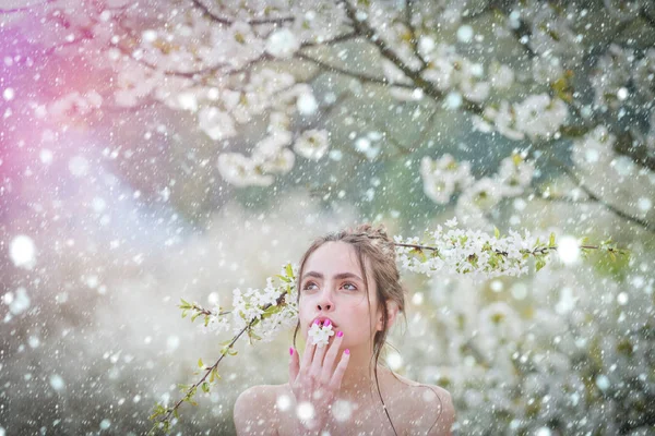 Красивая женщина наслаждается запахом в цветущем весеннем саду — стоковое фото