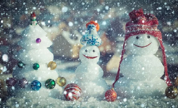 Bonecos de neve com rostos sorridentes em chapéus no dia de inverno — Fotografia de Stock