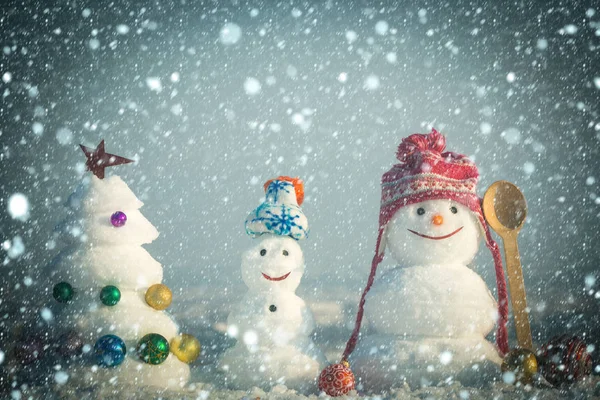 Χιονάνθρωποι με χαμογελαστά πρόσωπα σε καπέλα χειμώνα ημέρα — Φωτογραφία Αρχείου