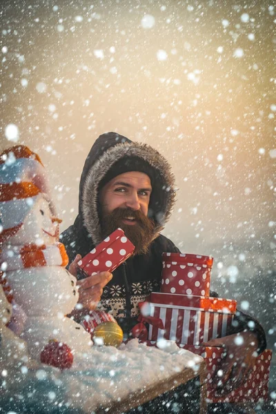 Ευτυχισμένος hipster με παρόντες κουτιά στο χιονισμένο τοπίο — Φωτογραφία Αρχείου