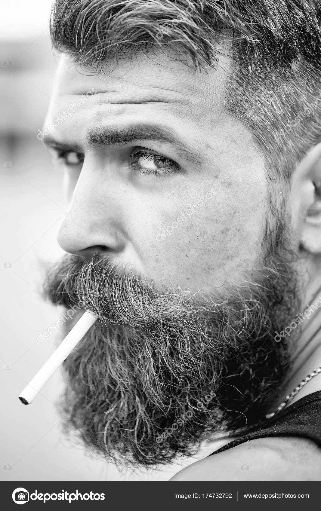Frown bearded man smoking cigarette — Stock Photo © Tverdohlib.com ...