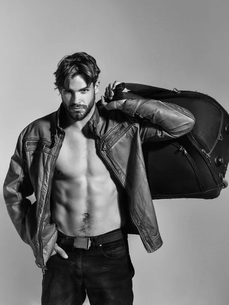 Muscular bearded man with sexy body holds big bag, suitcase — Stock Photo, Image