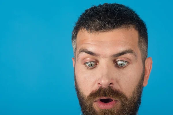 Человек с бородой на удивленном лице на синем фоне — стоковое фото
