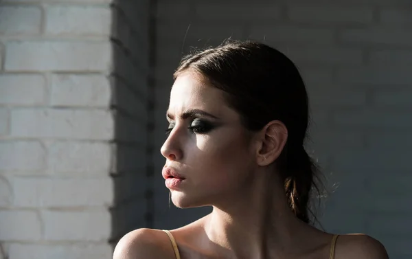 Perfil de cara de mulher na parede de tijolo branco — Fotografia de Stock