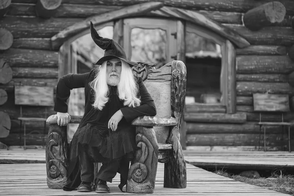 Old wizard in wooden chair — Stock Photo, Image