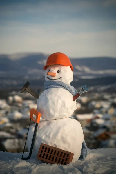 Nouvel an bonhomme de neige de neige avec scie et brique — Photo