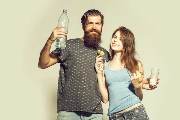 Улыбающаяся пара с бутылками воды — стоковое фото