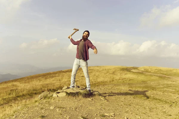 Bebaarde man met bijl op berg — Stockfoto