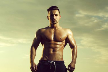 Gökyüzü arka plan üzerinde seksi kaslı adam