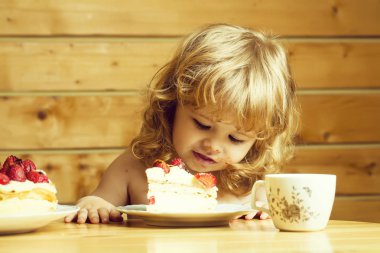 küçük çocuk çilekli kek yiyor