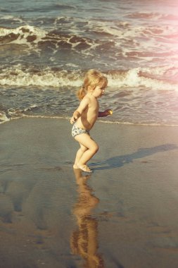 Islak kum deniz boyunca şirin neşeli bebek çocuk ishal