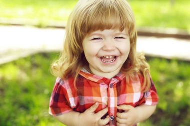 Yeşil çimenlerin üzerinde mutlu küçük çocuk