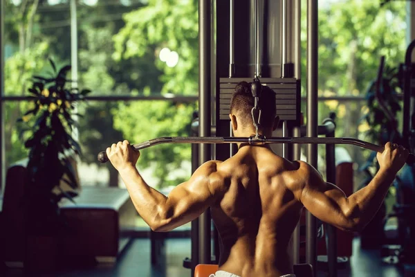 Musculoso hombre entrenamiento en gimnasio —  Fotos de Stock