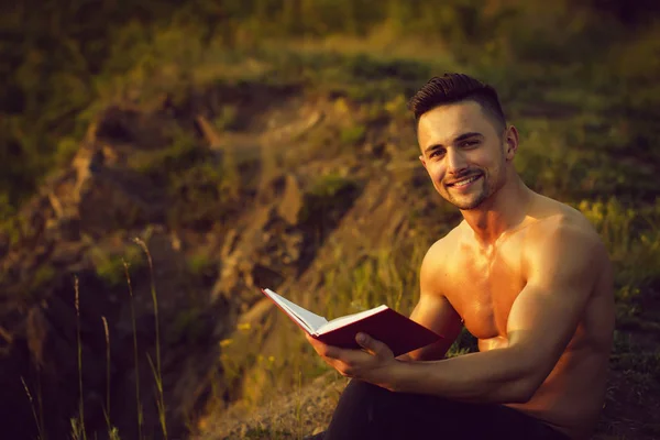 Uśmiechnięty mężczyzna mięśni z książki odkryty — Zdjęcie stockowe