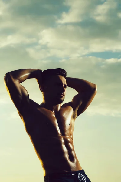 Sexy muskulöser Mann am Himmel Hintergrund — Stockfoto