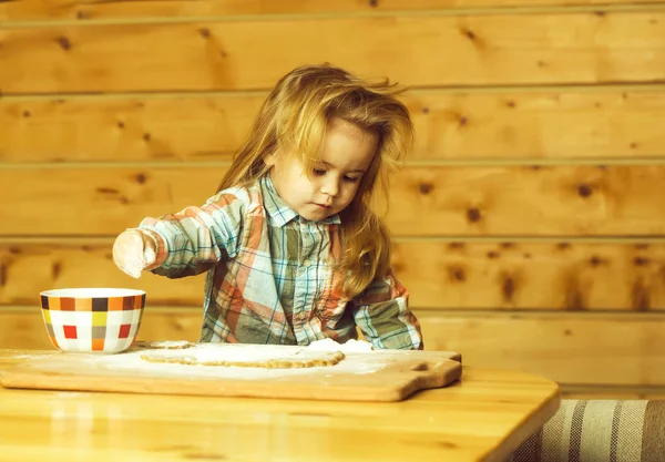 Criança bonito cozinhar com massa, farinha e tigela em madeira — Fotografia de Stock