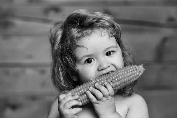 Legrační malý chlapec dítě jíst žlutá kukuřice — Stock fotografie