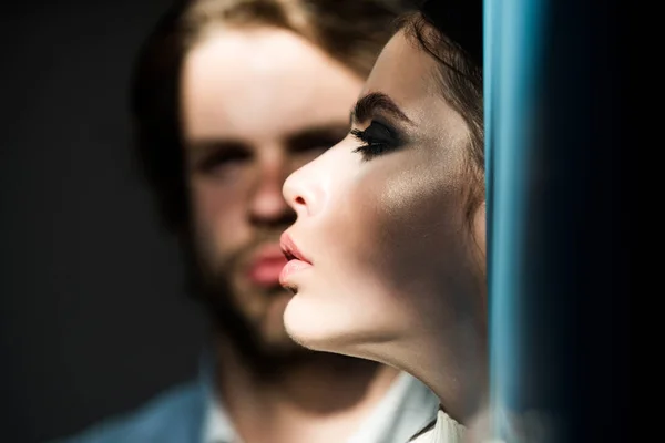 Профіль жіночого обличчя з розмитим чоловіком на фоні — стокове фото