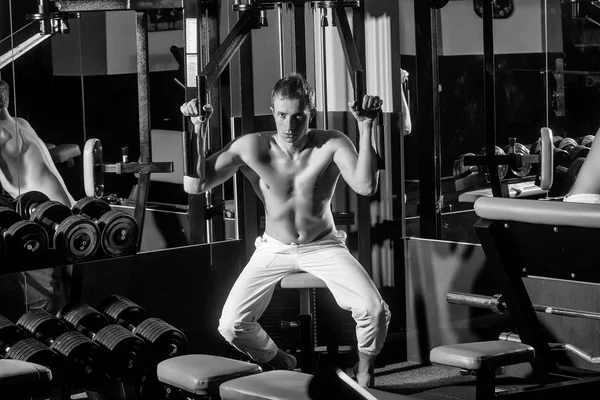 Sexy hombre con musculoso entrenamiento corporal levantamiento de pesas en gimnasio equipm —  Fotos de Stock