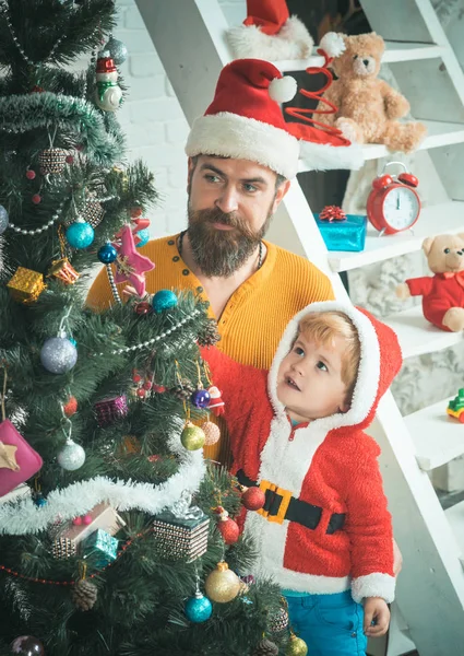 Papai Noel criança e homem barbudo na árvore de Natal . — Fotografia de Stock